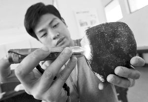 工作人员用专用手电判断内在玉石有无价值 现代快报记者 赵杰 摄