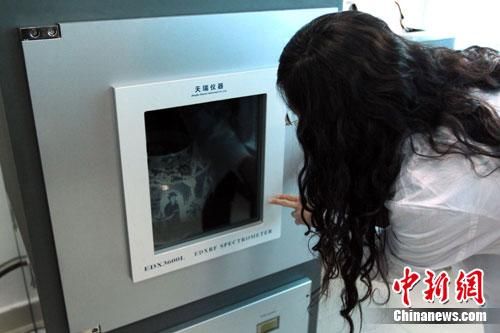 工作人员正在通过仪器检测陶瓷。中新网发孟幻摄 