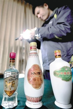 鉴定师正在鉴定一瓶市民家藏酒的出产年份及保存品质 记者 施健学 文/摄 