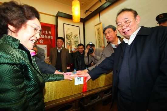 故宫博物院研究员 文化部艺术品评估委员会委员许丽（左一）、故宫博物院书画组组长著名文物鉴定家潘增亮（右一）为汪国新艺术品《朋友》系列---中国首个诗书画资产包封包贴封。