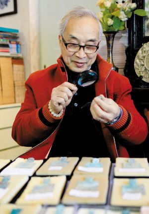 岑钟书在鉴赏古钱币。
