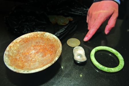 昨日，朝天门水上派出所，民警展示渔夫捞起的部分古玩。记者 龙在全 摄