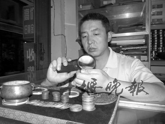 许向东正在潜心研究收藏的钱币