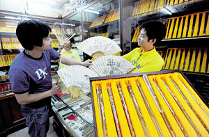 图为古玩城一家店铺内市民正在选购文玩折扇。