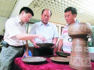 广东省工艺美术珍品馆馆长谭伟彬(图左)、广西钦州坭兴陶行业协会副会长李人?(图中)、广西省工艺美术大师陆景平(图右)正在商讨坭兴陶发展大计。