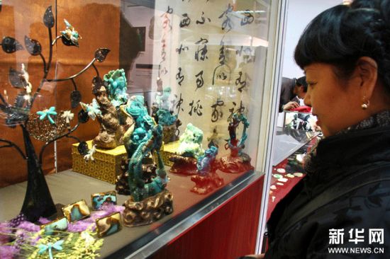 一名顾客在欣赏宝石“蓝玉髓”(俗称台湾蓝宝)工艺制品