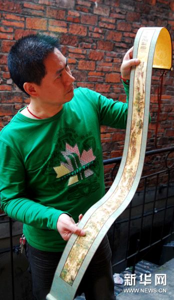 4月11日，谢仁山在展示其创作的袖珍彩墨烙画《清明上河图》　