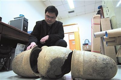 文物所工作人员正在查看瓮棺 徐娜摄