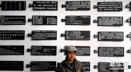 藏族画家格罗德站在自己的作品《藏式木板上的文字》前