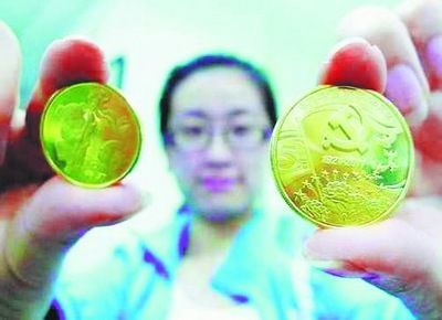 图为中国共产党成立90周年普通纪念币（右）和2011年贺岁普通纪念币