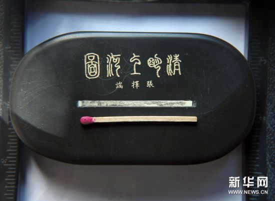郭月明创作的《清明上河图》微雕作品与一根火柴长度相近