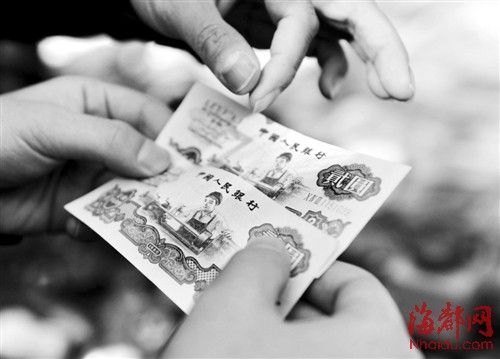一市民正在辨别纸币的真伪