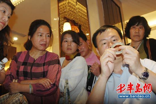杨鹏在现场为青岛市民鉴定收藏的玉石品 