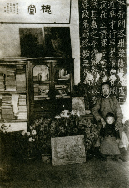 图1 陈师曾与其子在家中合影，桌前花卉油画据考证系李叔同早期作品，亲自赠予陈师曾收藏