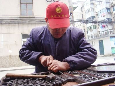 图为王道林用凿子铲。刘峰生 摄