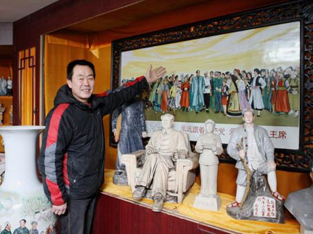 图为民间收藏家张涛展示他收藏的毛主席瓷雕作品。