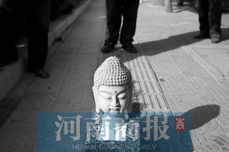 考古专家称，这尊佛头只能算个工艺品，可能是路边卖假文物的小贩落下的。