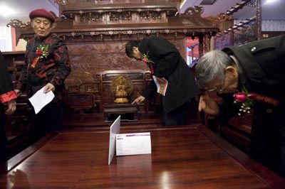 古典红木家具专家王秀林(左)、胡德生(中)、杨家驹在北京一处家具商城查看红木家具的品质。