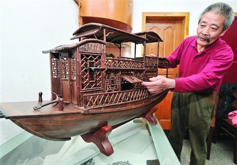 苏州民间艺人张红根在展示历时一年多精心制作的一艘仿古红木戏船。