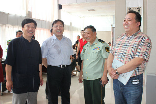 谢飞、韩双增将军、著名鉴赏家曹明章和当地领导谈画展内容