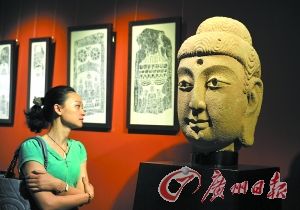 市民驻足欣赏北魏时期山西佛像的典型代表圆雕佛首。