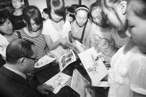 翁教授在画展上给“粉丝”签名。