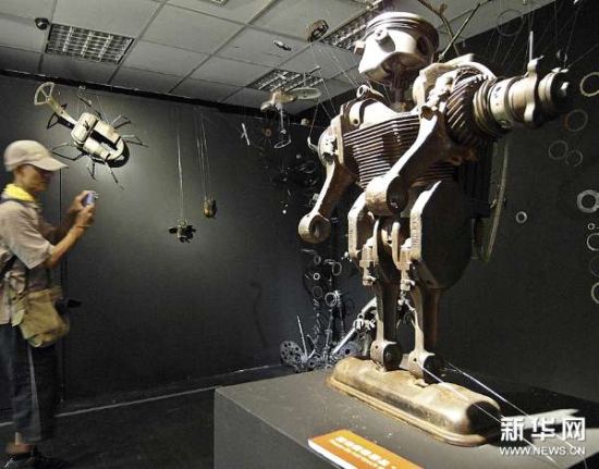 7月4日，参观者在拍摄由废旧物品制作的展品。