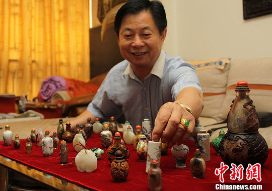 湖南长沙收藏爱好者黄振强在家中展示自己收藏的鼻烟壶。