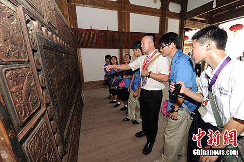 图为来自台湾台南的中学师生来到福州三坊七巷小黄楼参观一人多高、号称中国最大牌匾的“功崇业广”匾所惊叹。中新社发 刘可耕 摄