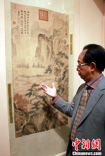 图为该公司主席在介绍唐伯虎的《松云山居图》。中新社发 孙宇挺 摄