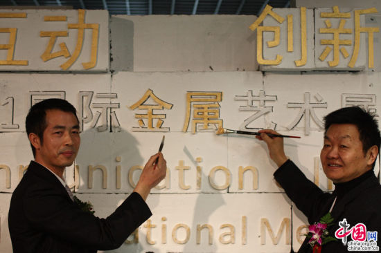 2011年11月6日，北京中华世纪坛当代艺术馆，第六届北京文博会组委会办公室副主任、北京贸促会副会长佘运高（左）与清华大学美术学院常务副院长郑曙?（右）为艺术展“描金”。当日，“互动 创新??2011国际金属艺术