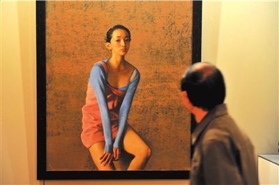 一名观众在欣赏李晓刚的《芭蕾舞演员》。本报记者胡雪柏摄