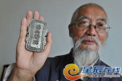 易老展示家传的清朝总兵腰牌。朱炎皇 摄