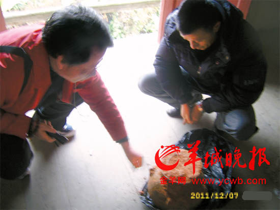 盗墓者展示一个沾满红泥的四系罐，开价1万元。