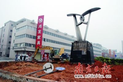 钩机在写有“大涌”字样的雕塑旁作业。