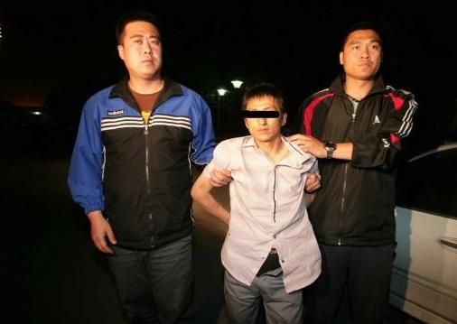 2011年5月11日，警方将故宫大盗石柏魁(中)抓获归案。资料图