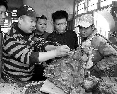 图为22日，在施厝村一玉雕加工坊，师傅施碧顺(左一)正在教工人雕刻销往台湾的玉雕作品。