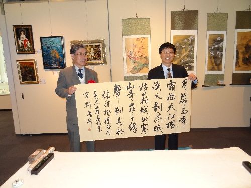 重庆书法家协会主席刘庆渝，日本书道院院长石川方云现场进行书画交流并互赠作品。(重庆日报图)