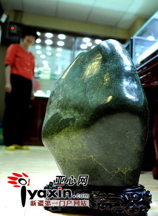 图为一位销售商给记者展示店内的一块“大块头”玛纳斯碧玉，这块重约四十余公斤的碧玉目前市场售价约万元左右。亚心网记者 张万德 摄