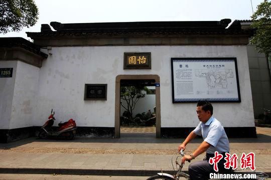 一位市民骑电瓶车，从昔日顾家大宅过云楼的后花园怡园门口经过。李克祥摄