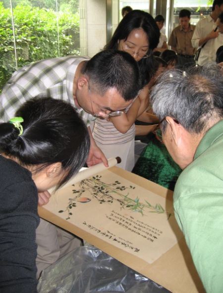 朱万章（中）在鉴定书画。