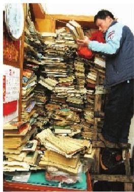 2月14日，苏利群站在楼梯上，整理墙角大书架上的藏书，这些只是他收藏的一部分书籍，还有更珍贵的一些明清和民国时的旧书，他都收在木箱里。