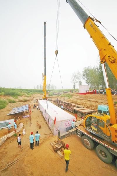 两台吨位级别在70吨的大吊车，将把打包后重达50吨的古船稳稳吊起，放置在一辆载重70吨的半挂牵引车上。