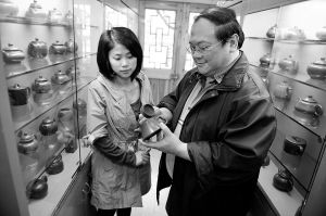谢麟祥（右）与蓝雪玲正在“千壶居”仔细端详宝贝壶儿色泽、光彩的细微变化。