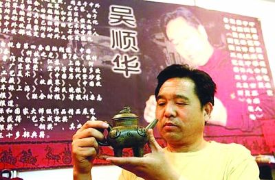 吴顺华先生正在钻研艺术作品。