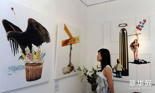 7月13日，游客在参观画展。新华网图片 宋振平 摄