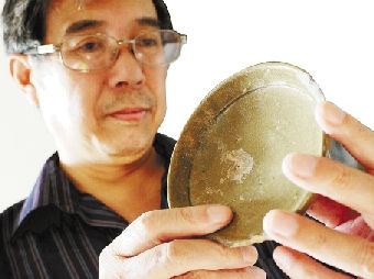 专家赵一新正在仔细察看下湖头村窑里发现的青瓷碗。.jpg