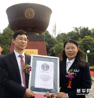 10月28日，在江苏如皋市，吉尼斯世界纪录认证官吴晓红（右）宣布“青铜万寿百岁碗”为“世界最大青铜碗”，并颁发吉尼斯世界纪录认证证书。新华网图片 许丛军 摄