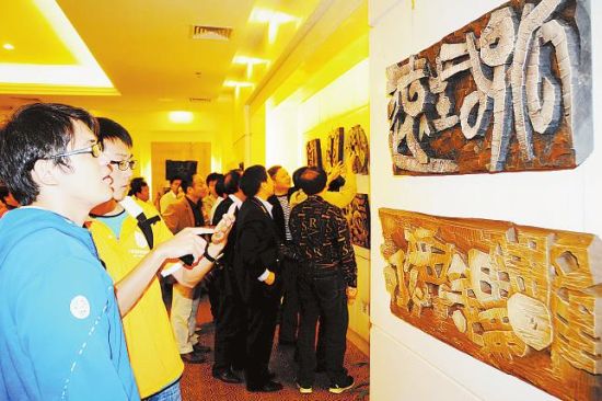 观众正在欣赏展出的书法篆刻作品 记者 潘浩摄