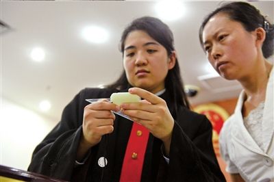 本报记者王秋实法官当庭测量玉牌大小。 本报记者蒲东峰摄